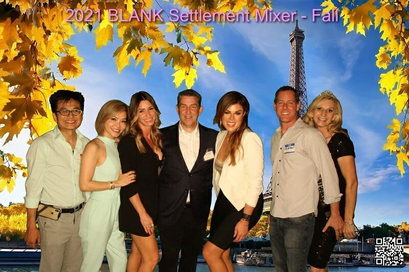 A group of people posing in front of the eiffel tower.