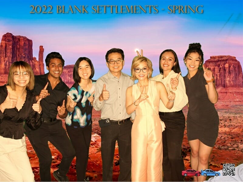 A group of people posing for a photo in front of a desert.