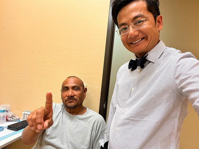 Dos hombres posando para una fotografía en el consultorio de un médico.