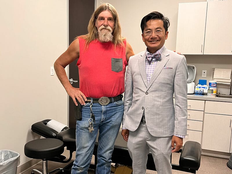 Two men standing next to each other in a doctor's office.