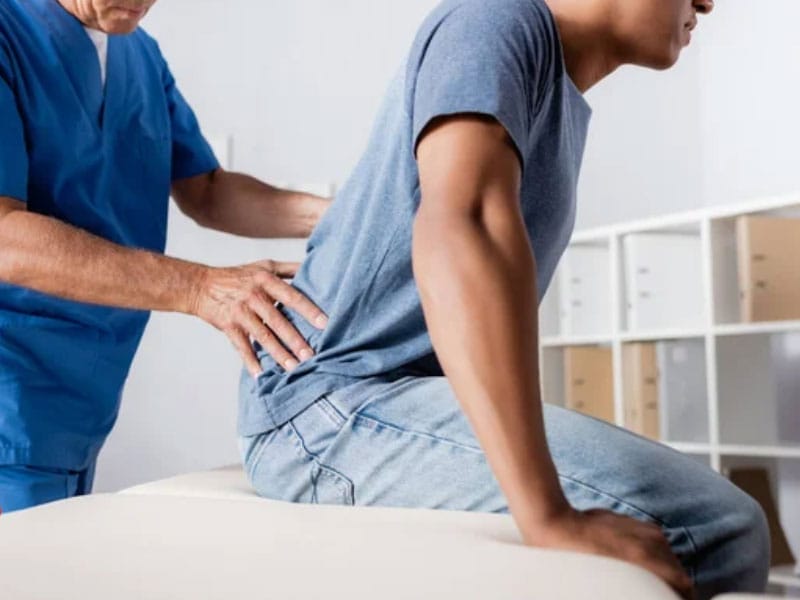 A man is having his back examined by a doctor.
