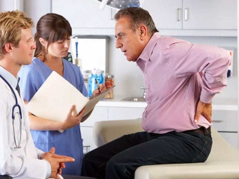 A doctor is talking to a patient about his back pain.
