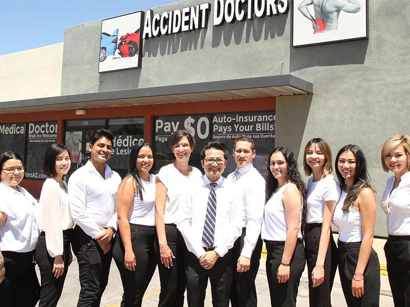 A group of people posing in front of an accident doctor's office.